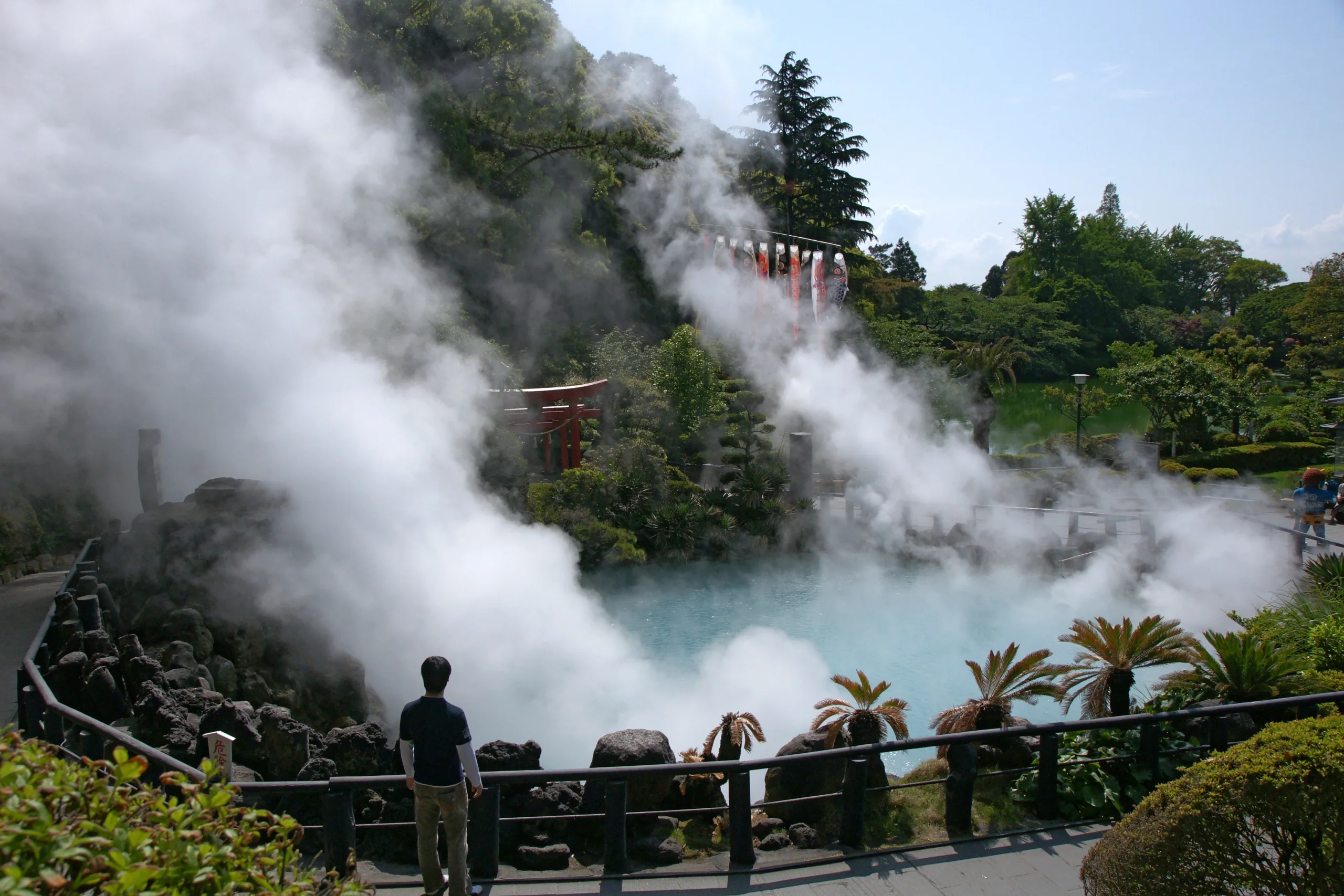 別府海地獄的藍色池水、蒸氣和園內樹木