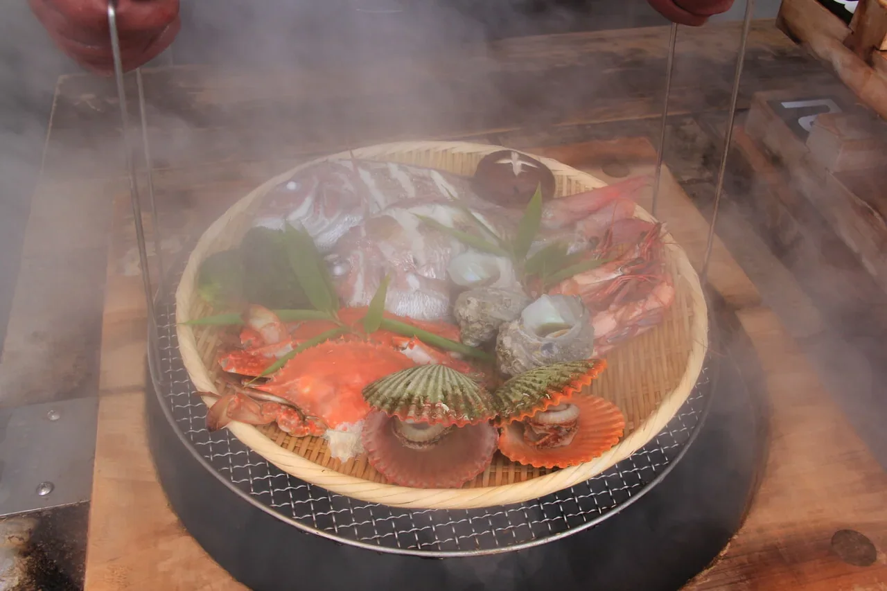 地獄蒸し工房鉄輪以蒸釜提起海鮮籃的操作示意