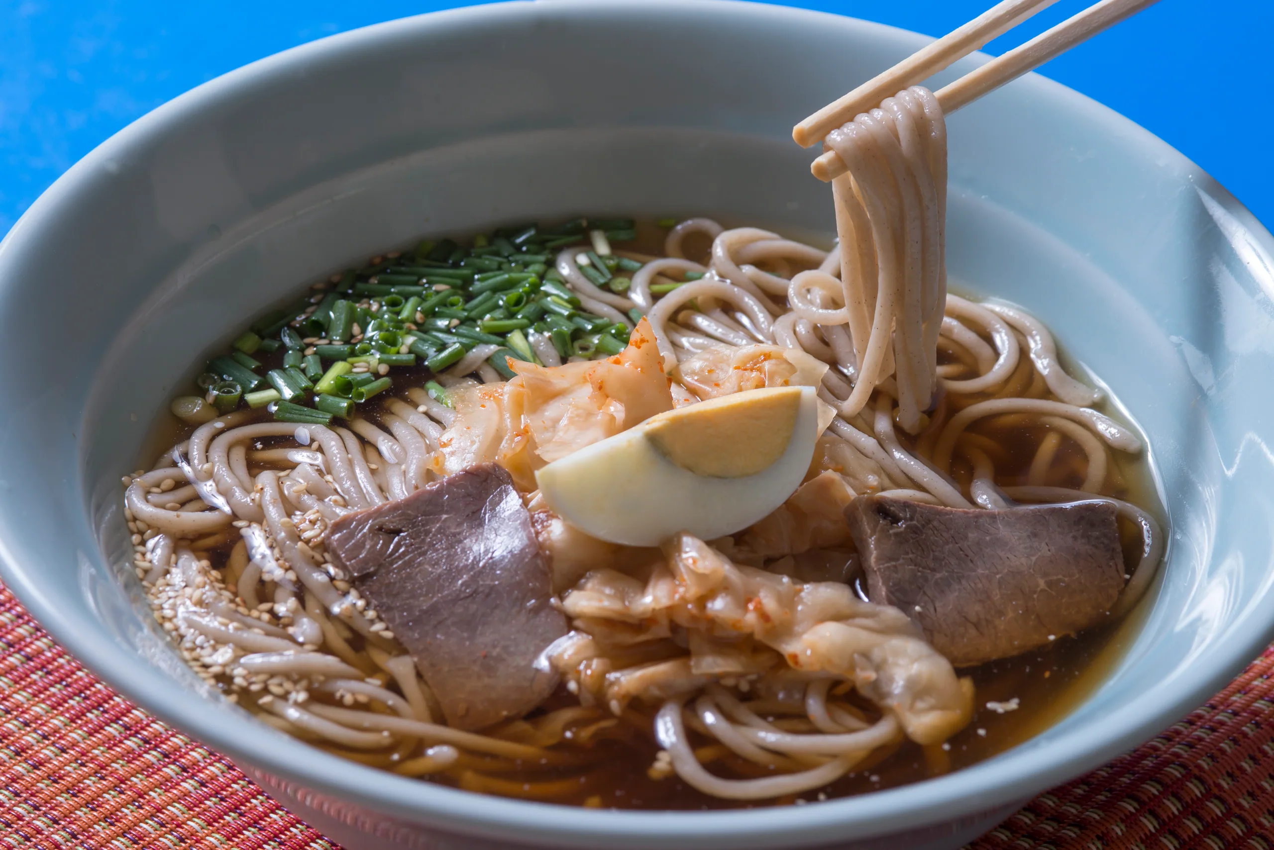 俯拍別府冷麵，冷湯中有牛肉、泡菜、蔥花和半顆蛋