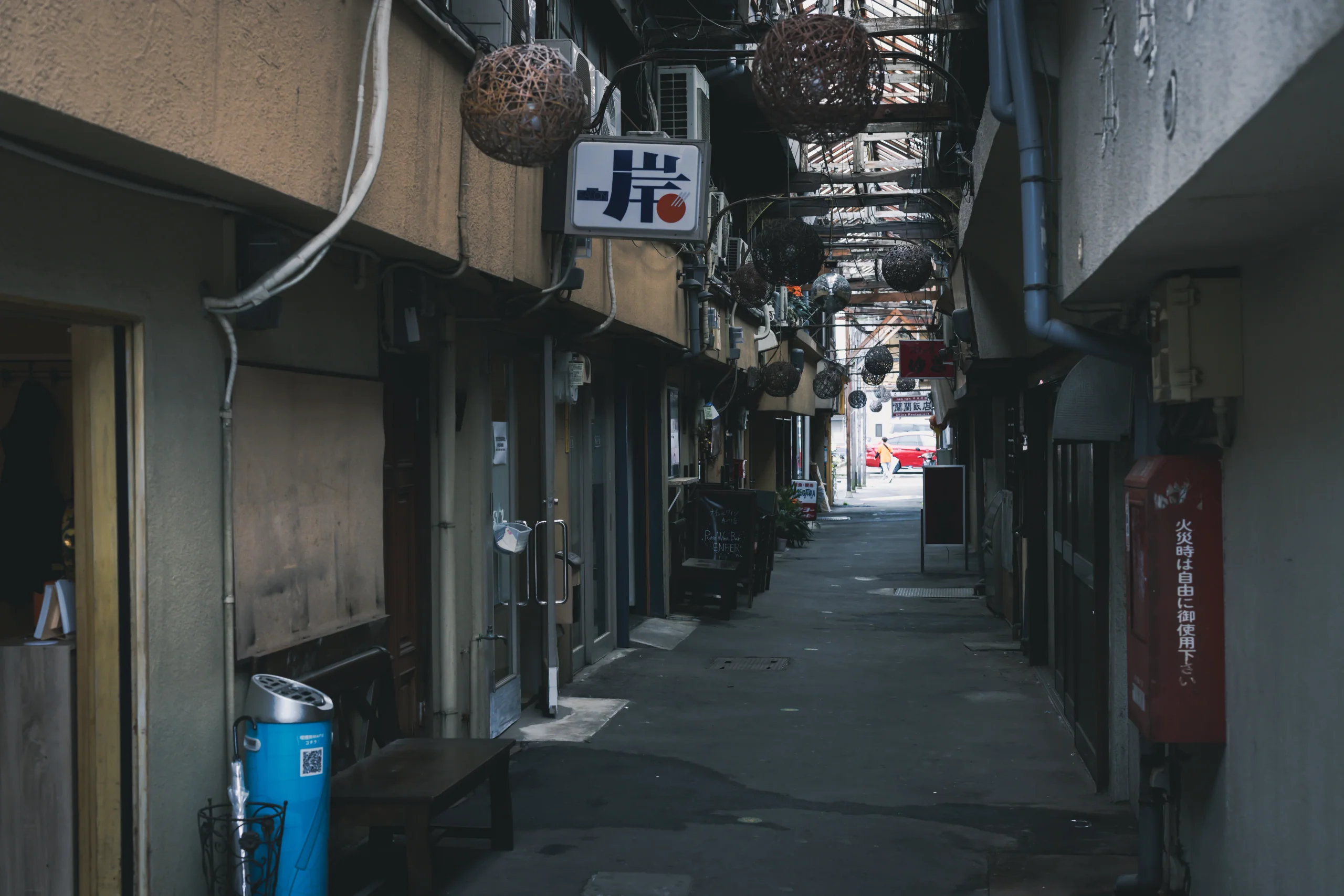 竹瓦小路拱廊內景，可見木造屋架、吊燈與巷道兩側店面
