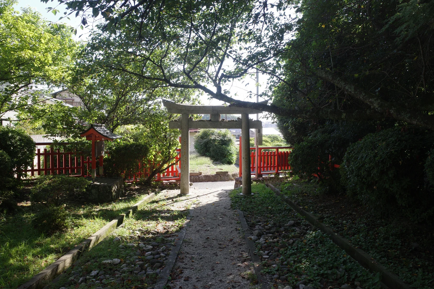 祐德稻荷神社境內的石鳥居、紅色圍欄與林間小徑