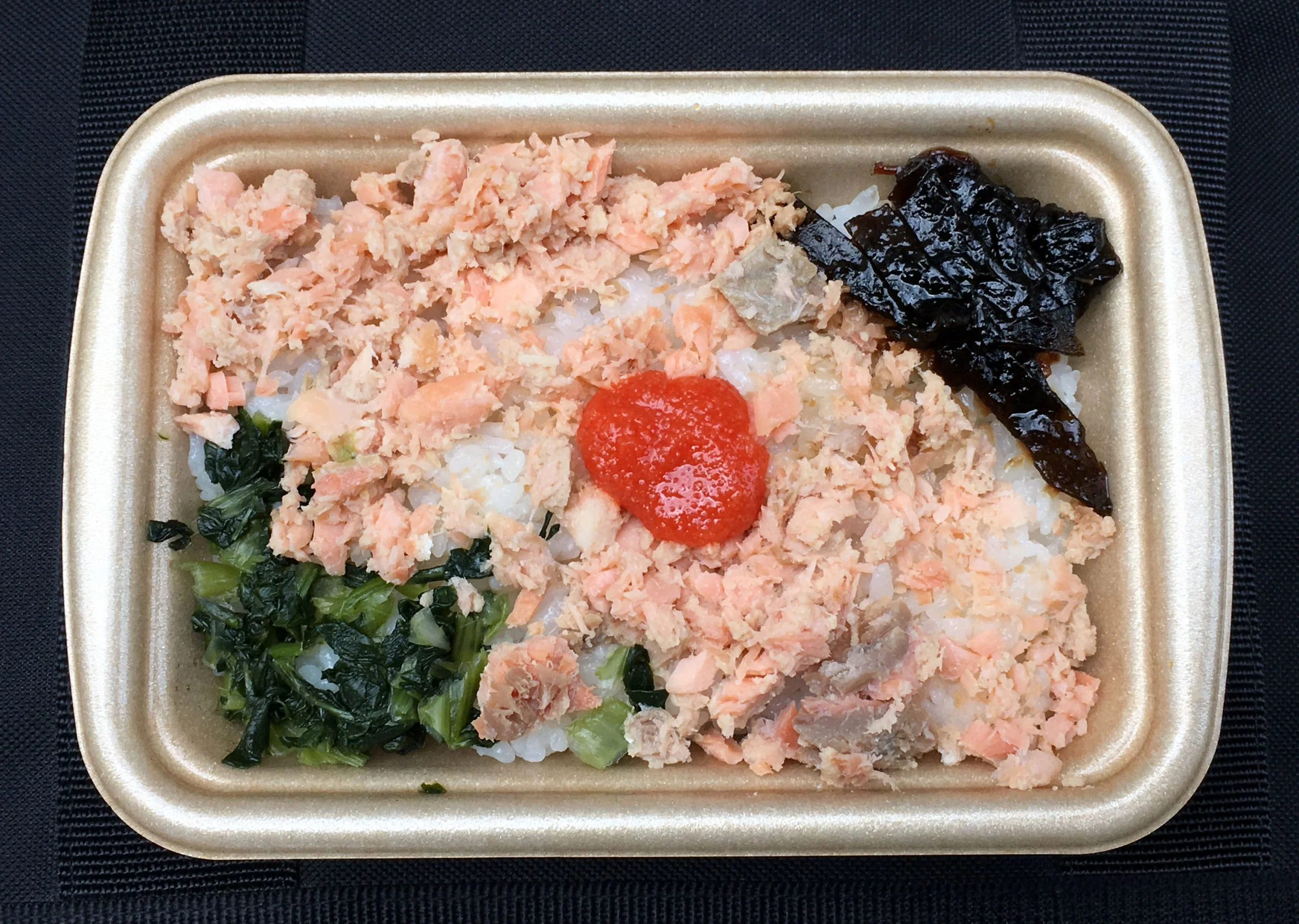 白飯便當上放有一小份明太子，旁邊配鮭魚碎和配菜