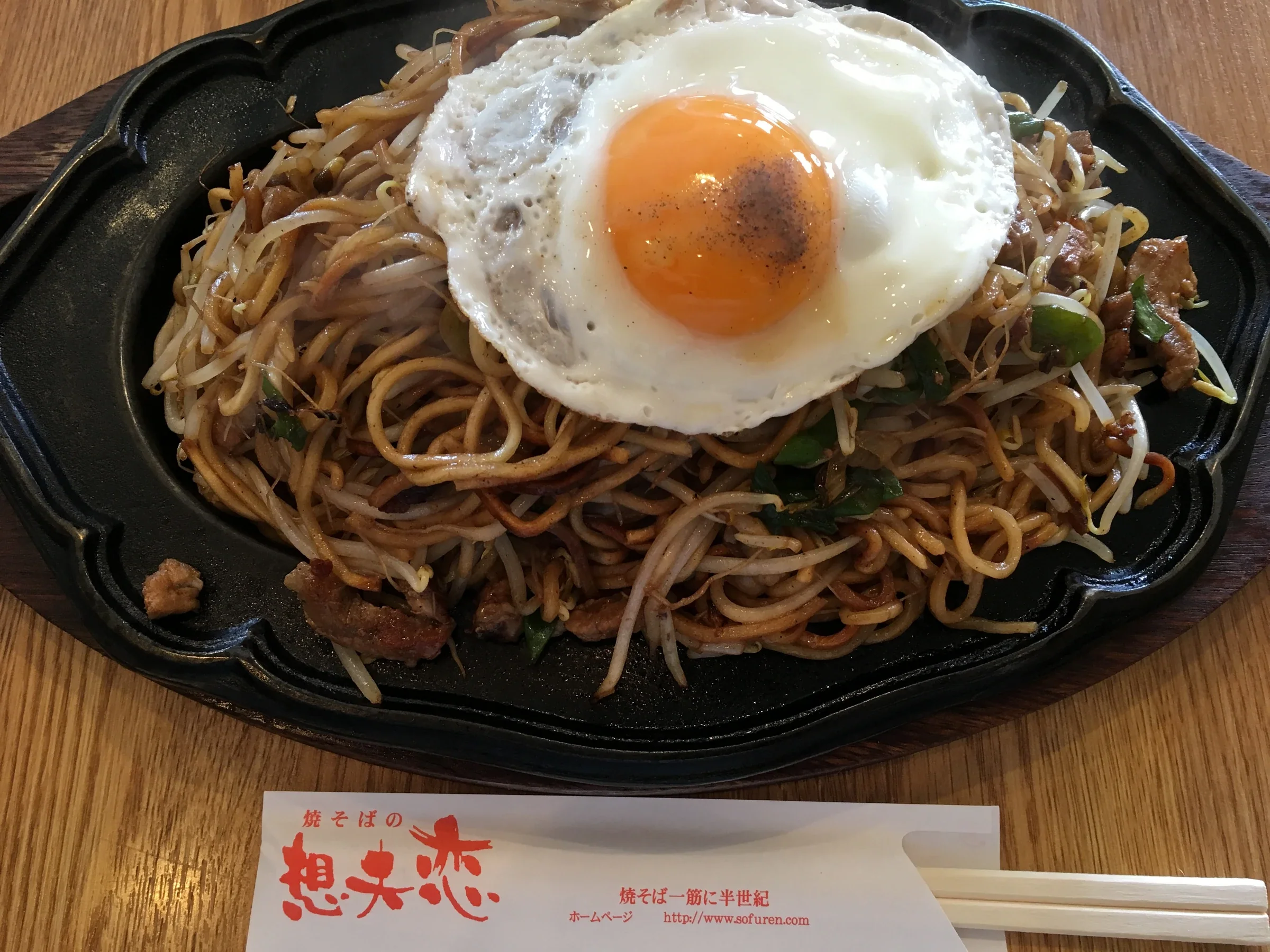 想夫戀日田燒そば盛在鐵板盤上，配有豆芽、豬肉和目玉燒