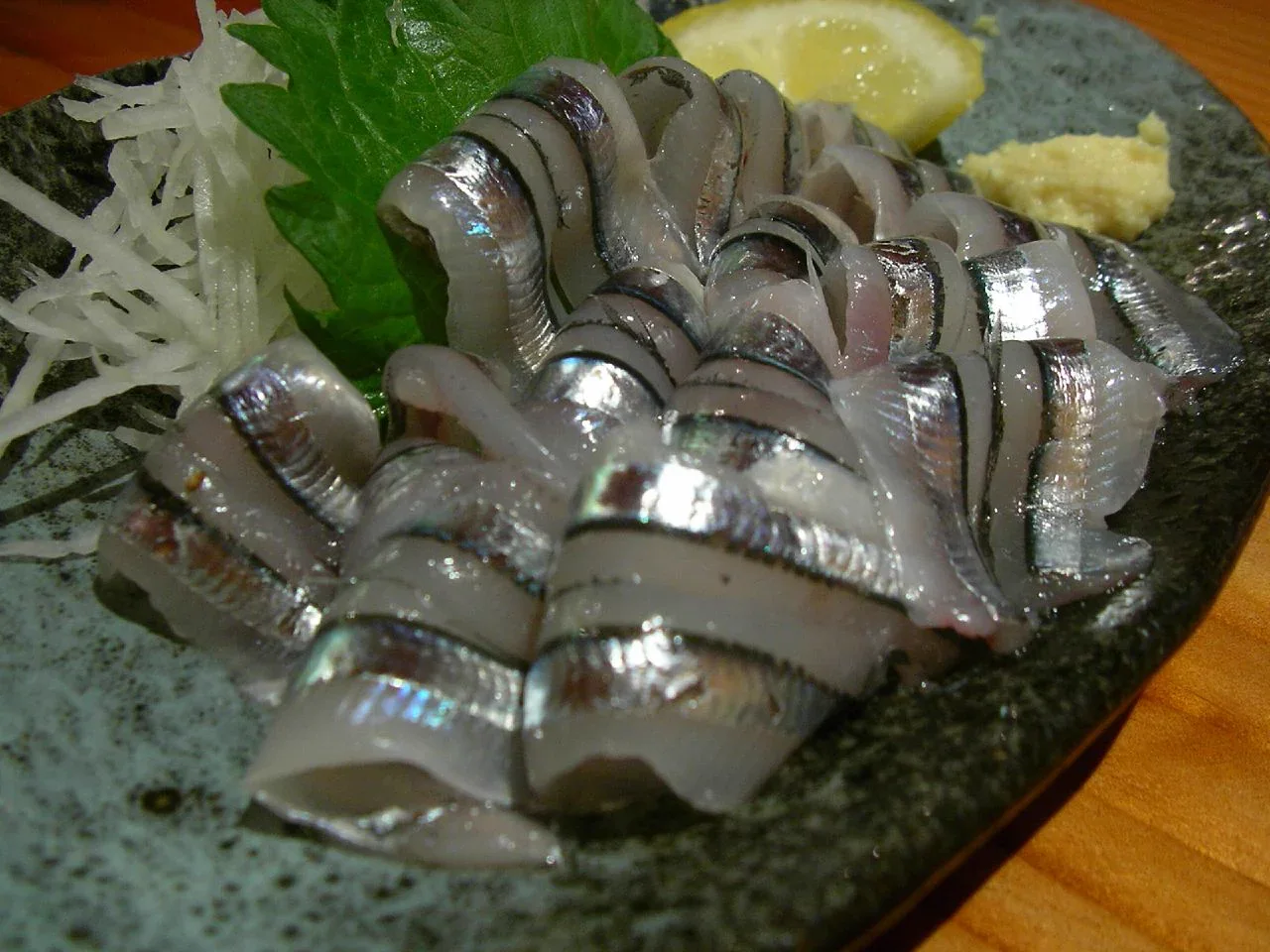 鹿兒島天文館居酒屋供應的きびなご刺身，銀白小魚排成菊花形，旁配藥味與檸檬