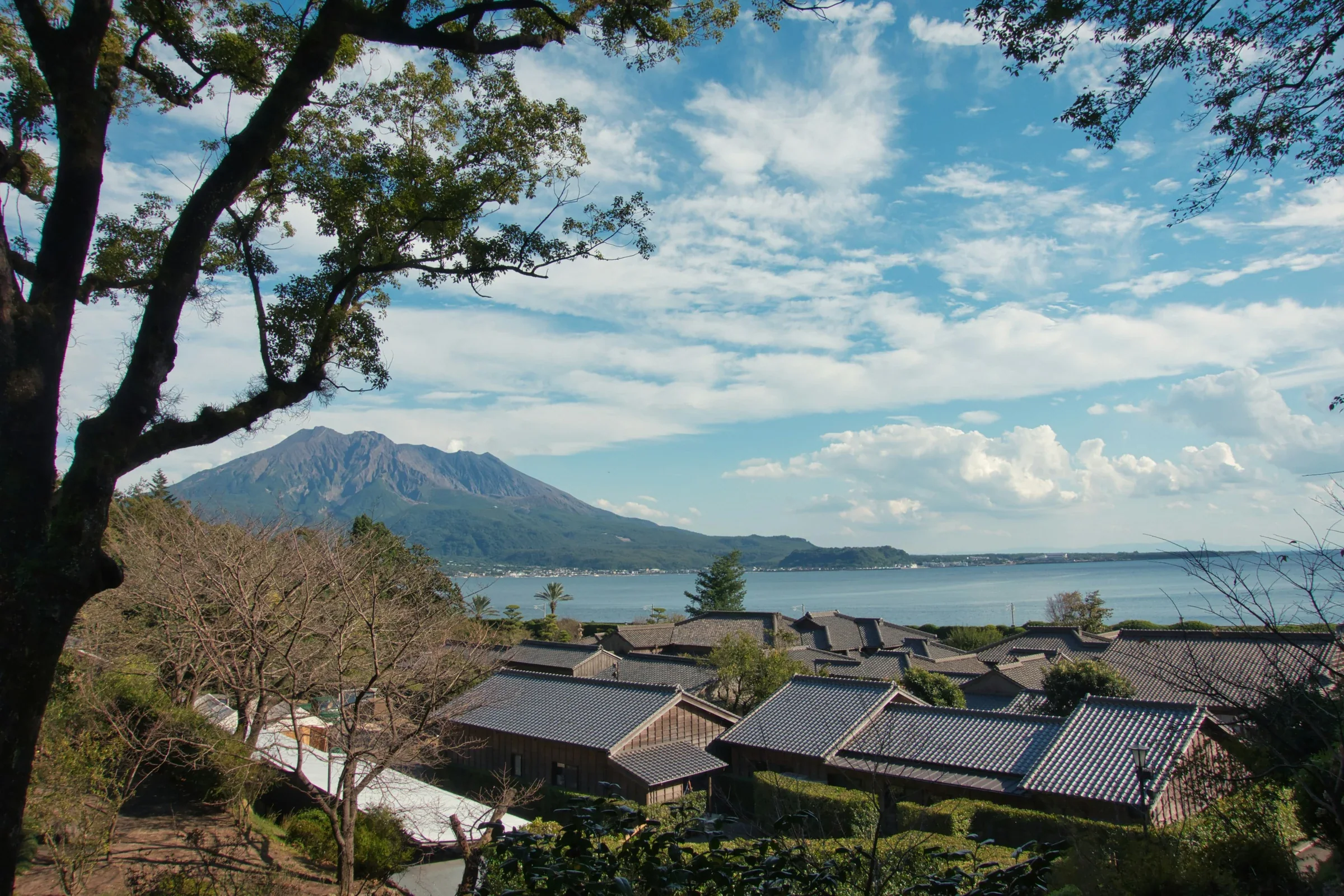 仙巖園池塘與庭園建築，遠景可見櫻島