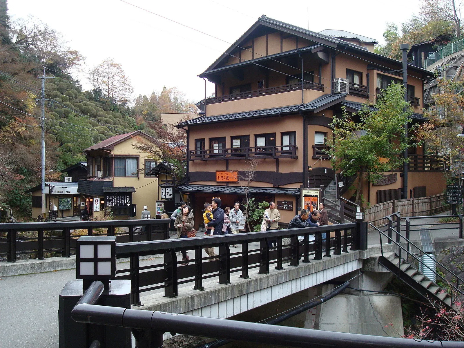 黑川溫泉街狹窄道路與傳統旅館街景，住宿位置會直接影響步行與自駕難度