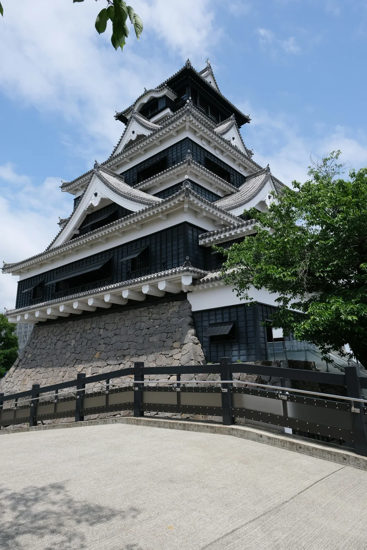 從下方仰望熊本城天守的白色屋簷、黑色外牆與石垣