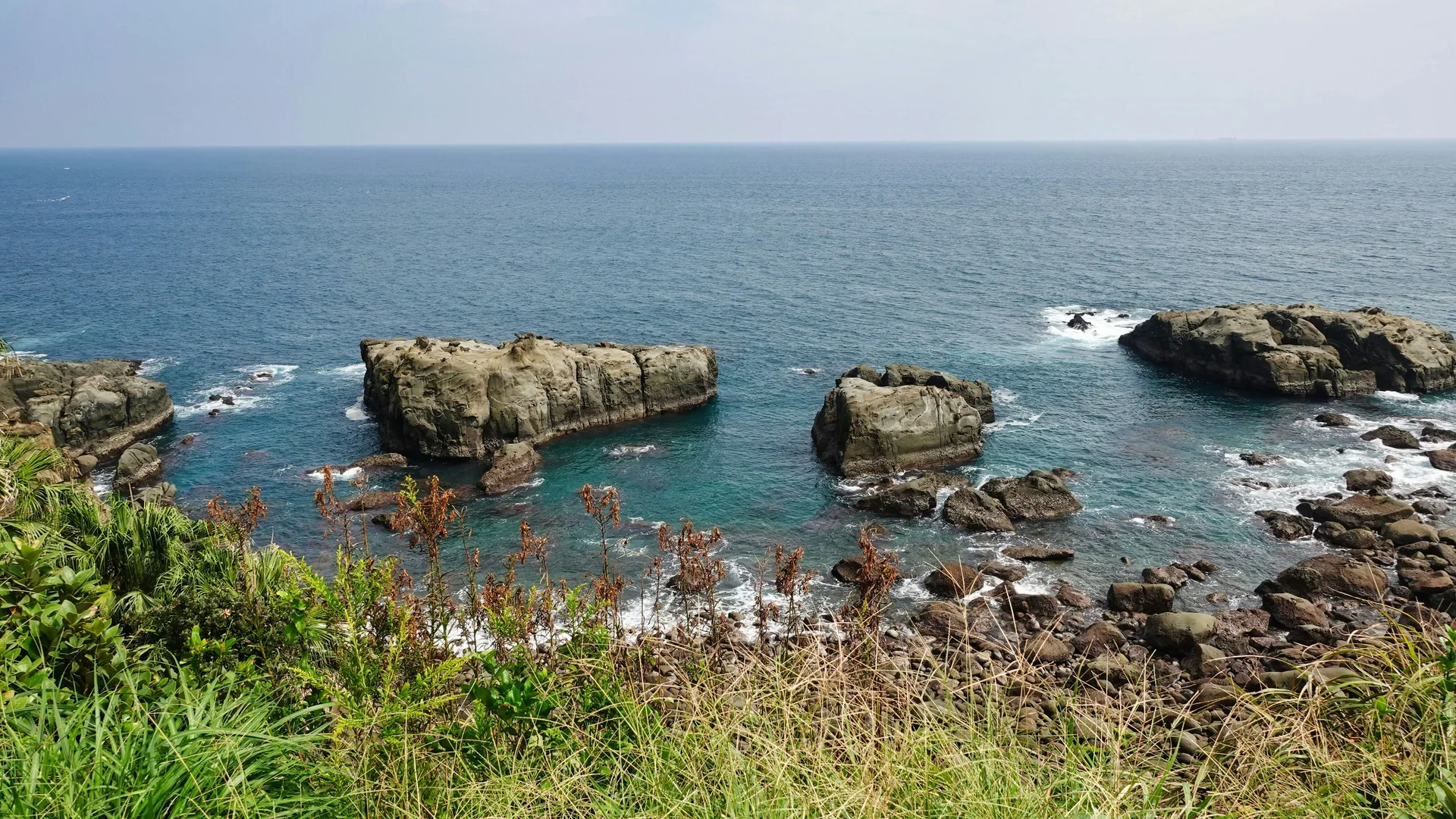 鵜戶神宮附近的日南海岸礁岩伸入海面，浪花沿岩岸散開