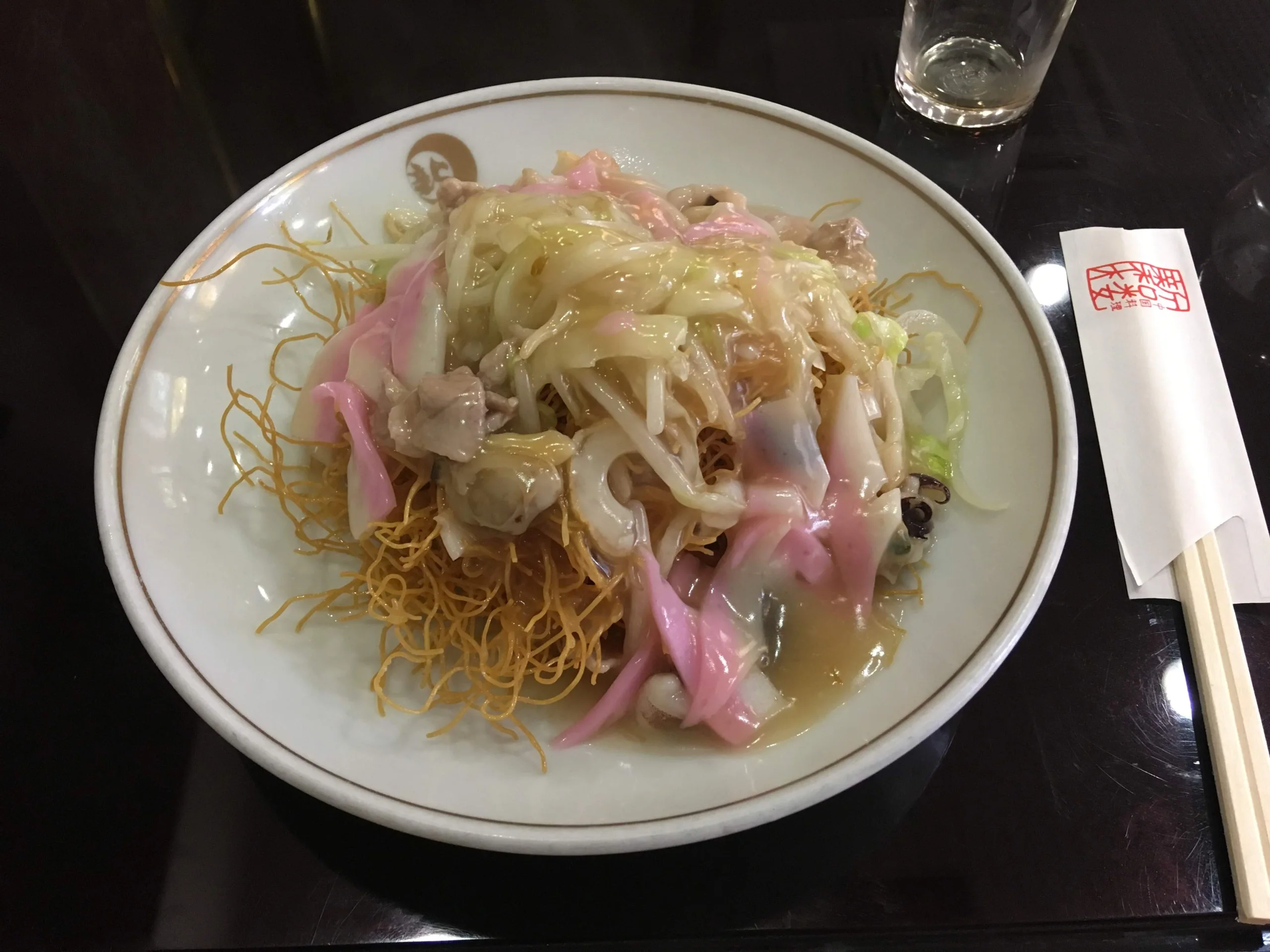 長崎新地中華街新和樓的皿うどん，炸麵上放有蔬菜、海鮮和粉紅色魚板