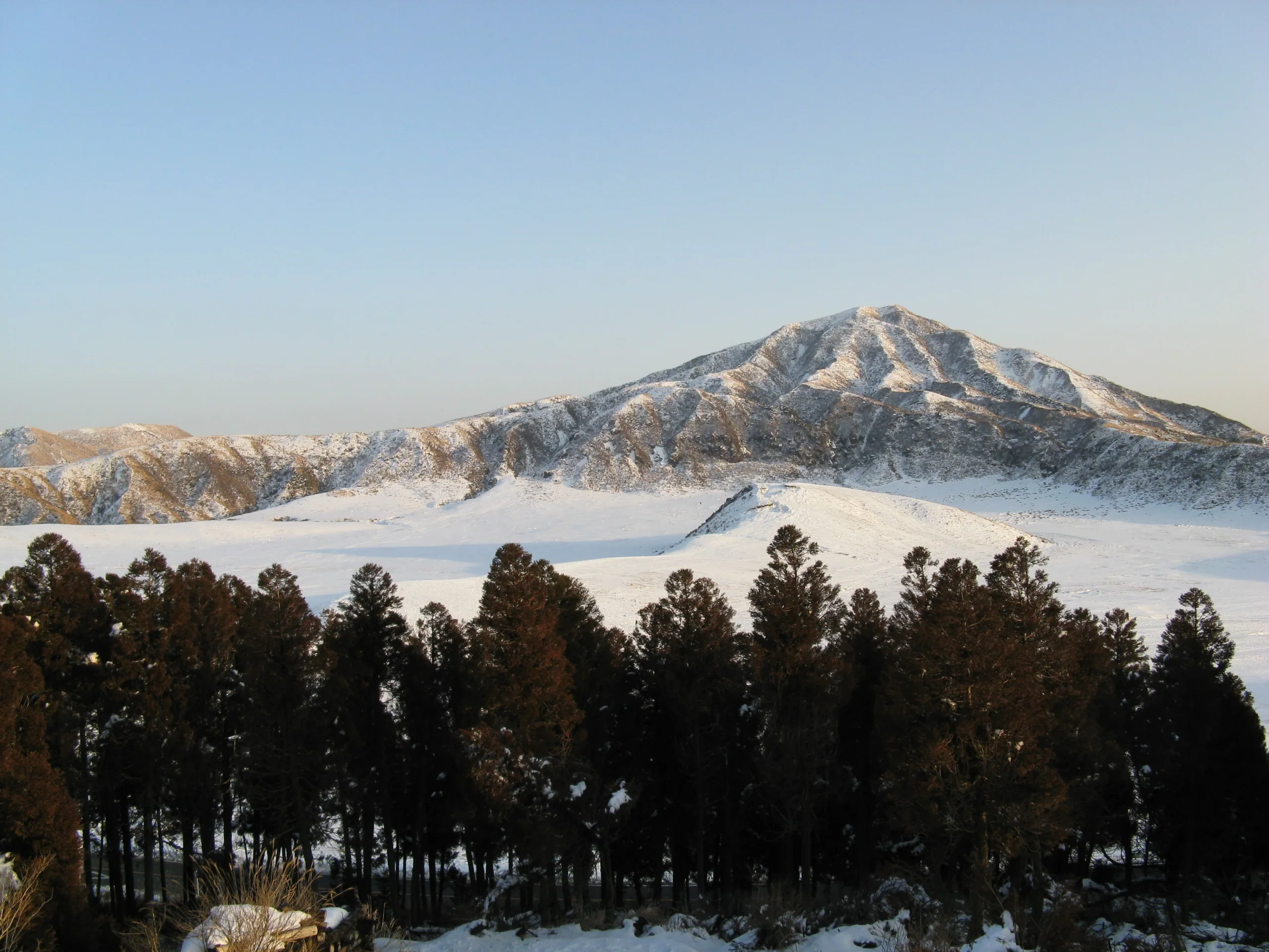 冬季雪後的阿蘇草千里與遠方山稜