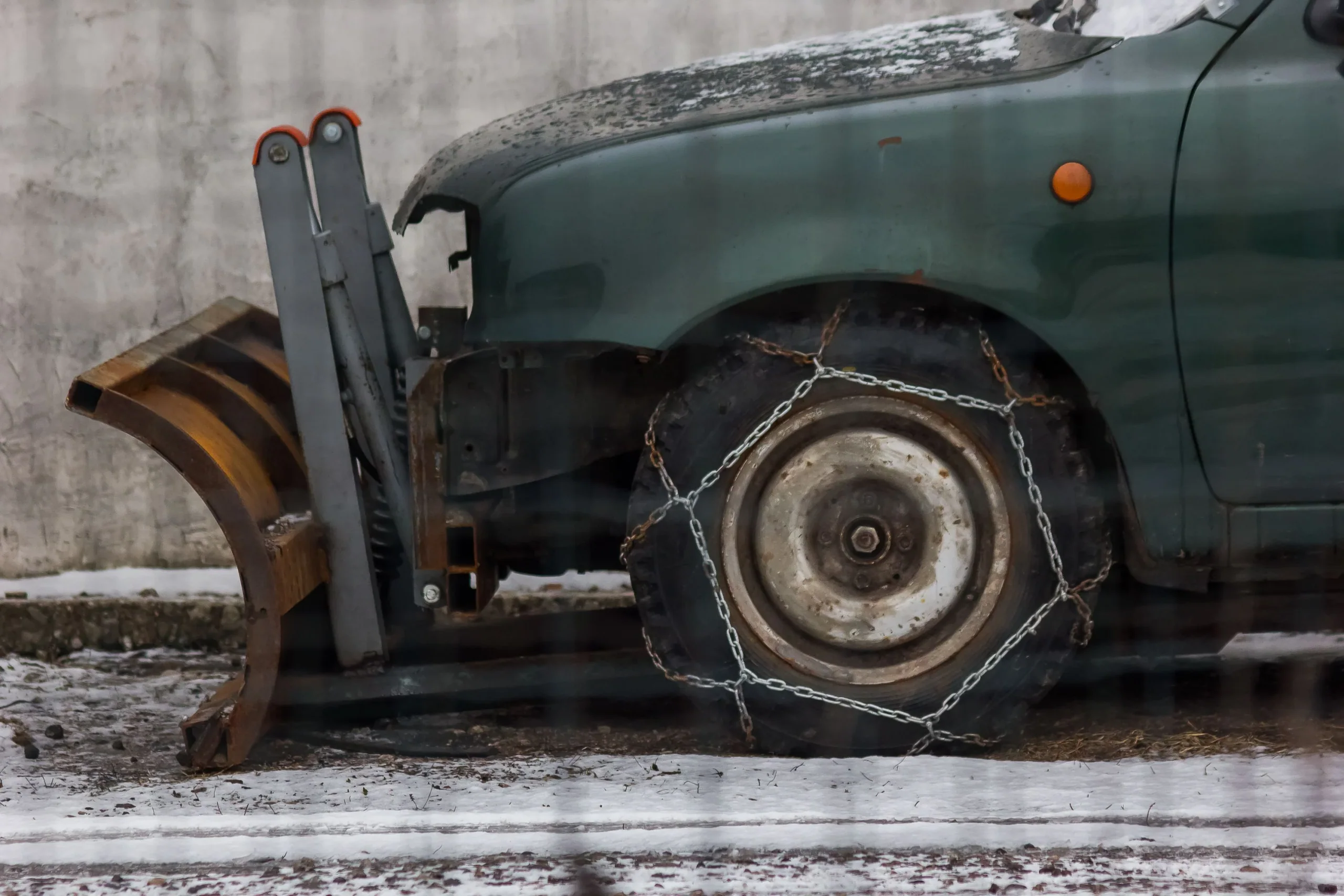 除雪車車輪套有金屬雪鏈,車輪停在薄雪地面