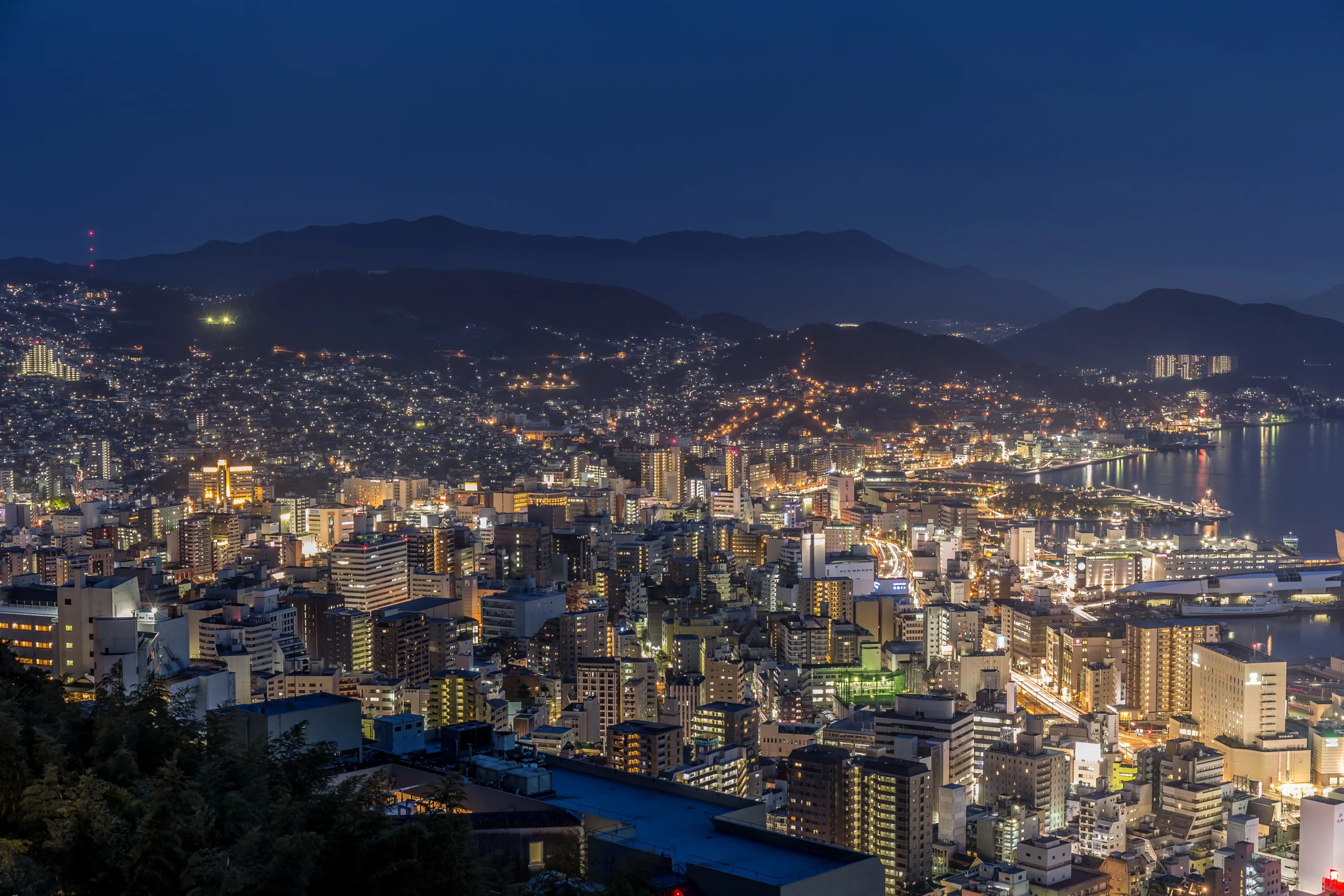長崎市夜間景色，山坡住宅燈光與港邊建築映在夜色中