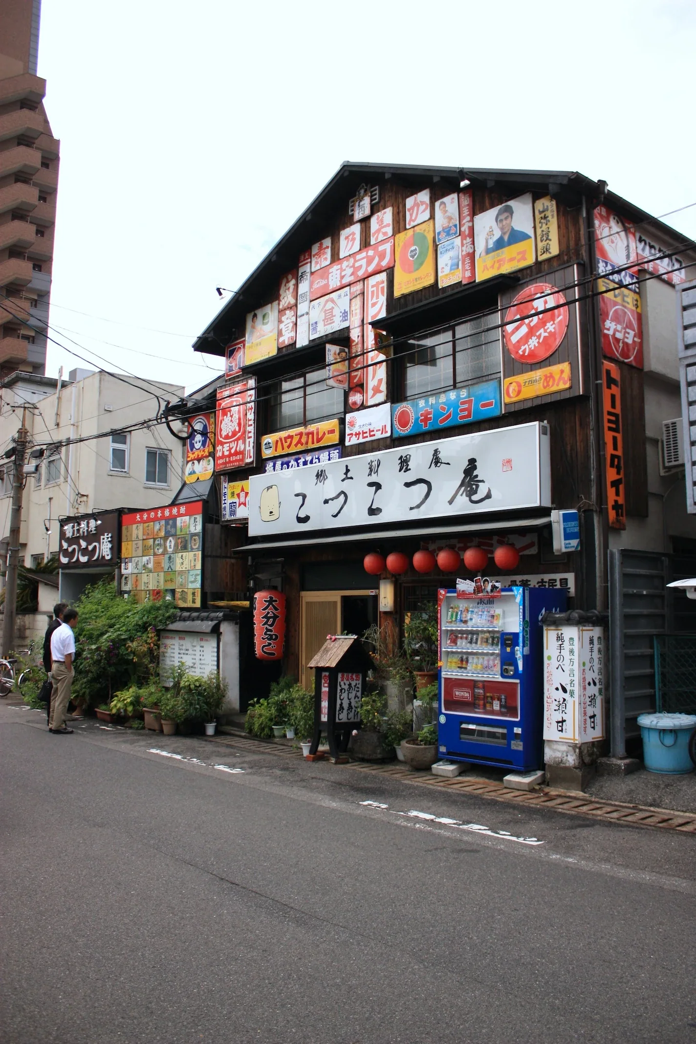大分府內町鄉土料理店こつこつ庵外觀，木造立面掛有店招和紅燈籠