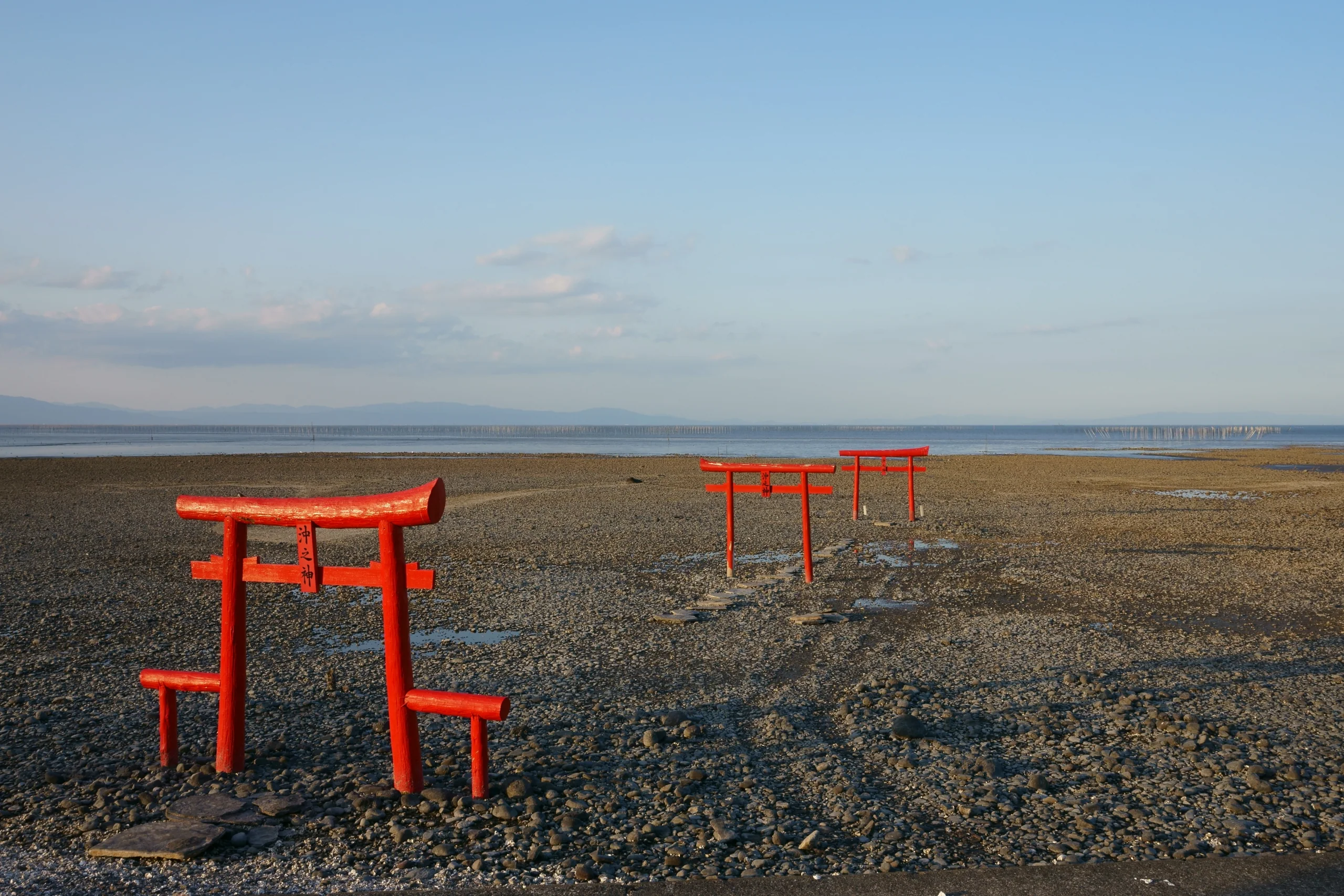 退潮時大魚神社三座海中鳥居立在有明海潮灘上，側面視角