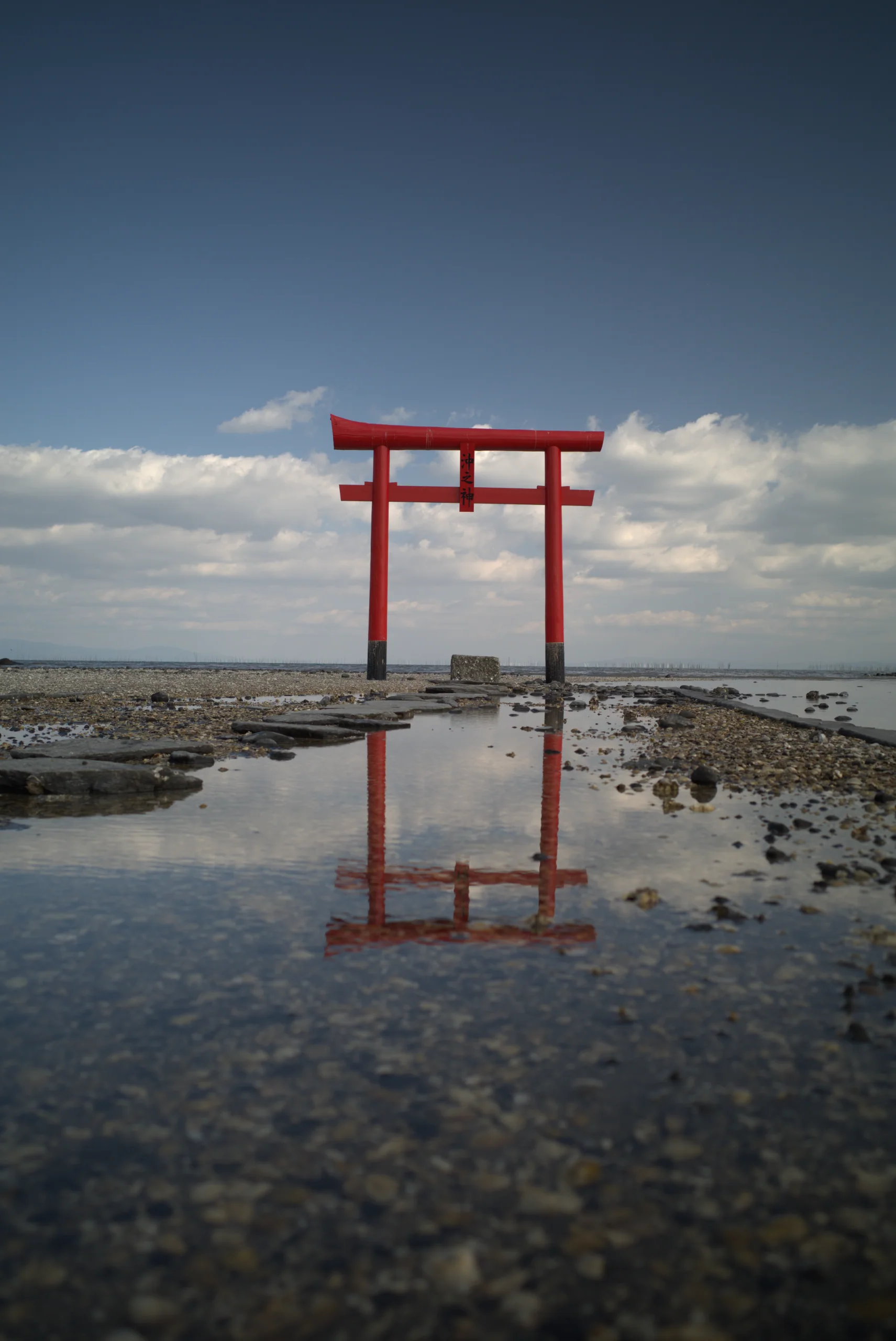 退潮的有明海上，三座朱紅色海中鳥居立在潮灘中，水面映出倒影