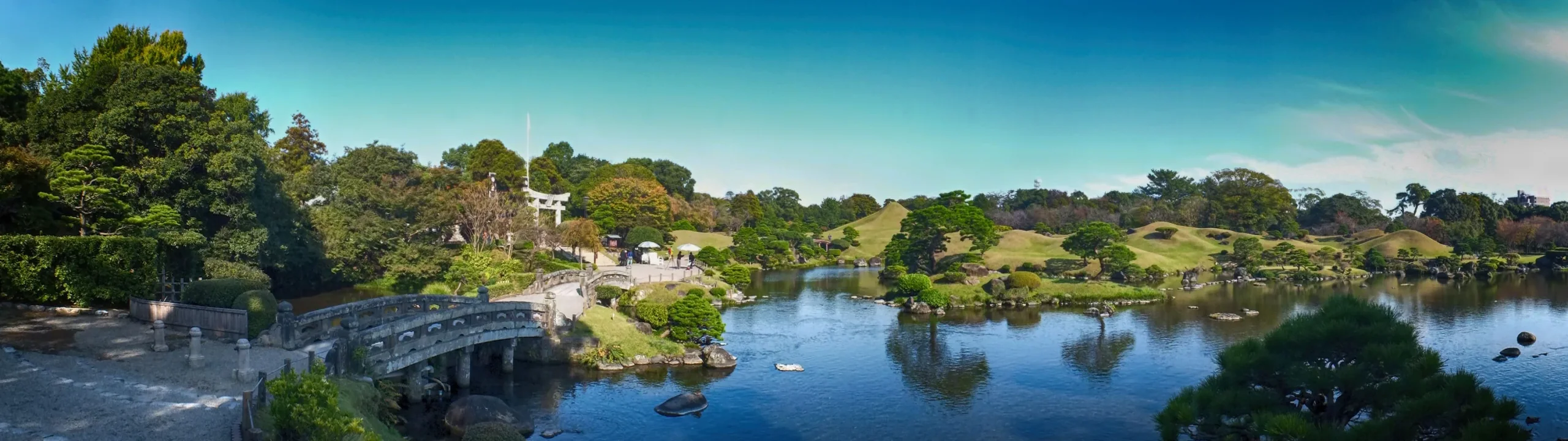 水前寺成趣園池畔石拱橋、築山與水面全景